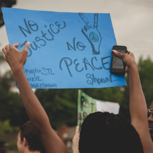 Photo of a sign being held at an event from the DocNow Collection. The sign reads: No Justice No Peace.