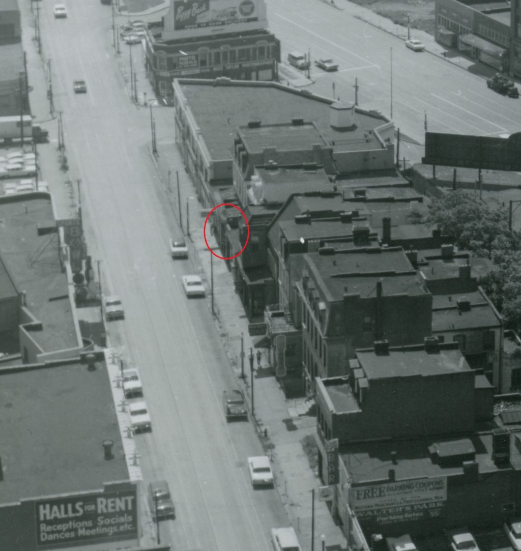 An aerial view of the 3500 block of Olive in the early 1960s, taken from the Continental Life Building looking toward the southeast. The location of Dante’s Inferno, the earliest known gay bar on the block, is circled in red. Dante’s Inferno had closed about a decade before this photograph was taken, but the exterior of the building probably remained more or less the same. Image courtesy of the Missouri History Museum. 