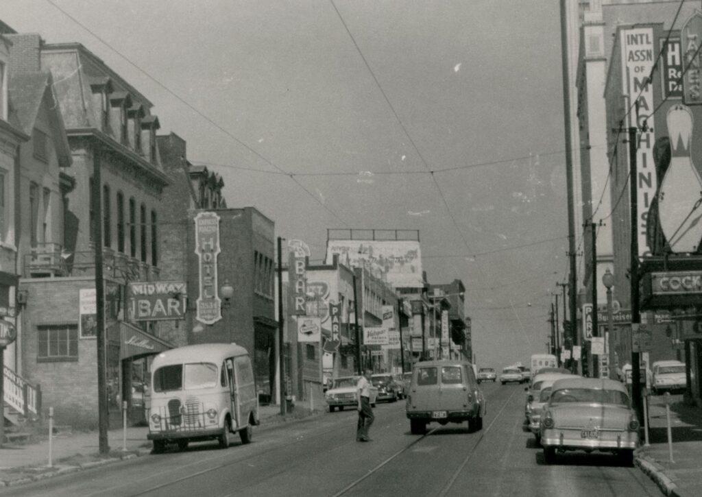 The 3500 block of Olive looking west toward Grand in the early 1960s. Shelley’s Midway Bar and the Golden Gate Bar are visible on the left side of the street. The Onyx Room is where the Schlitz sign can be seen farther down the street on the left. Image courtesy of the Missouri History Museum.