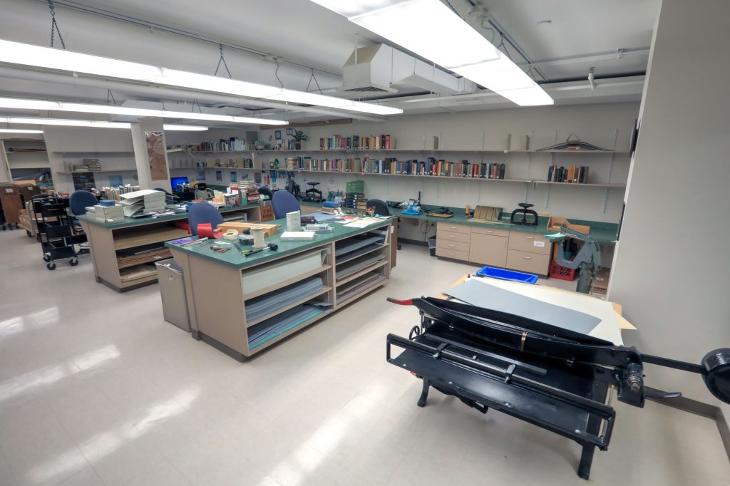 The Preservation Lab. There are multiple table stations and desks with various preservation-related items on all.