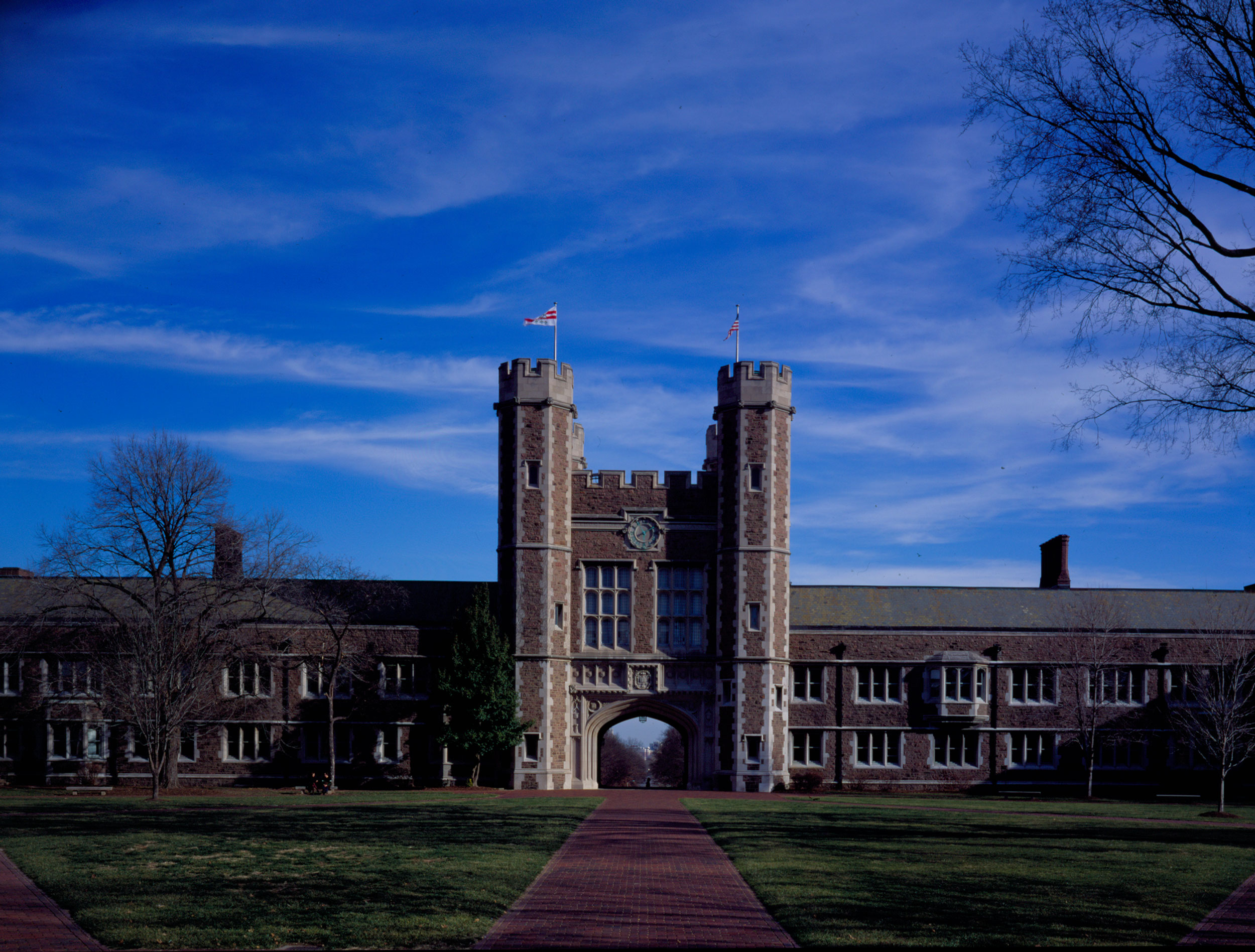 A campus photo of Brookings Hall. The walk-paths are clear and there is a rare, lovely blue sky in the background.