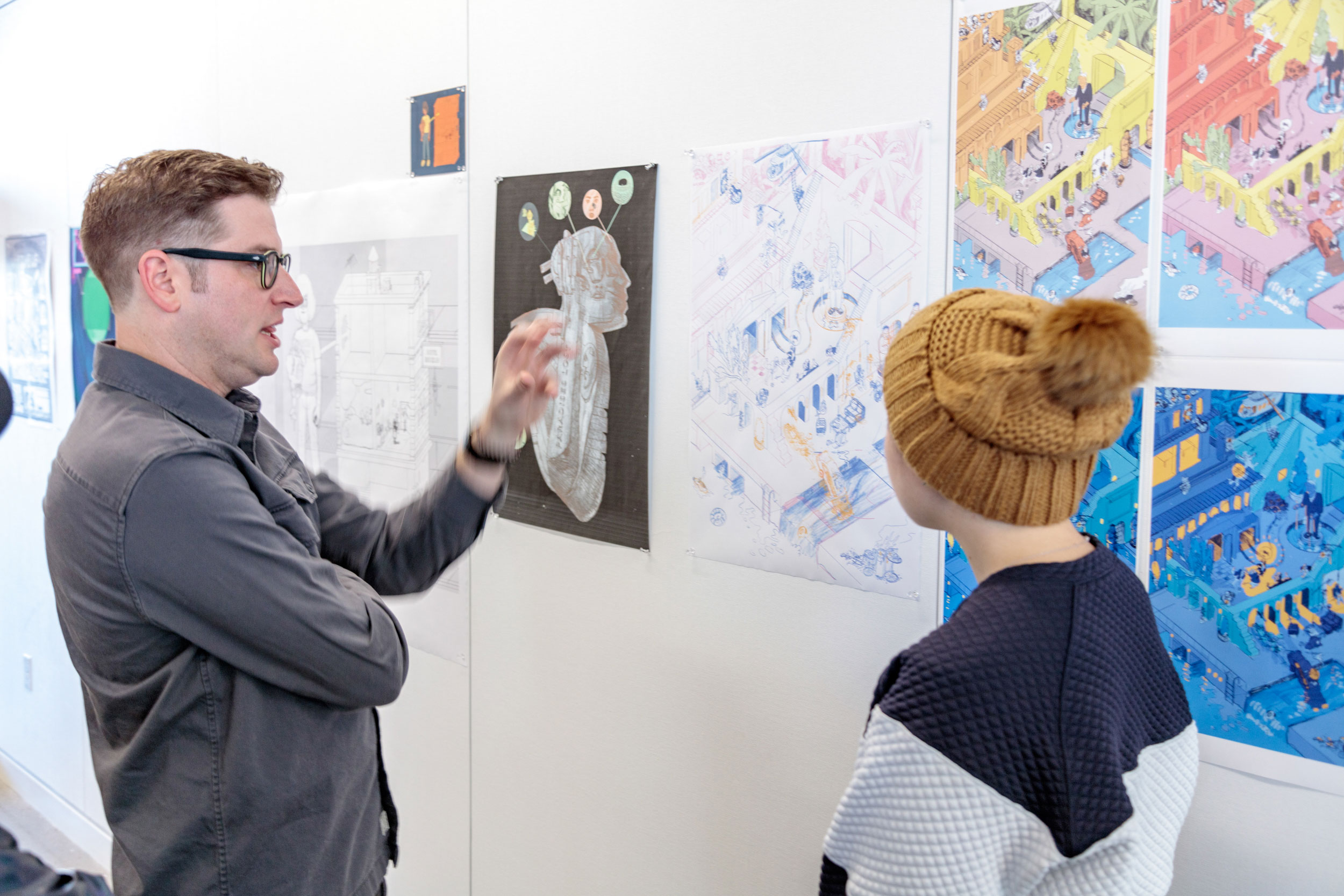 A faculty member and student discussing an art installation.