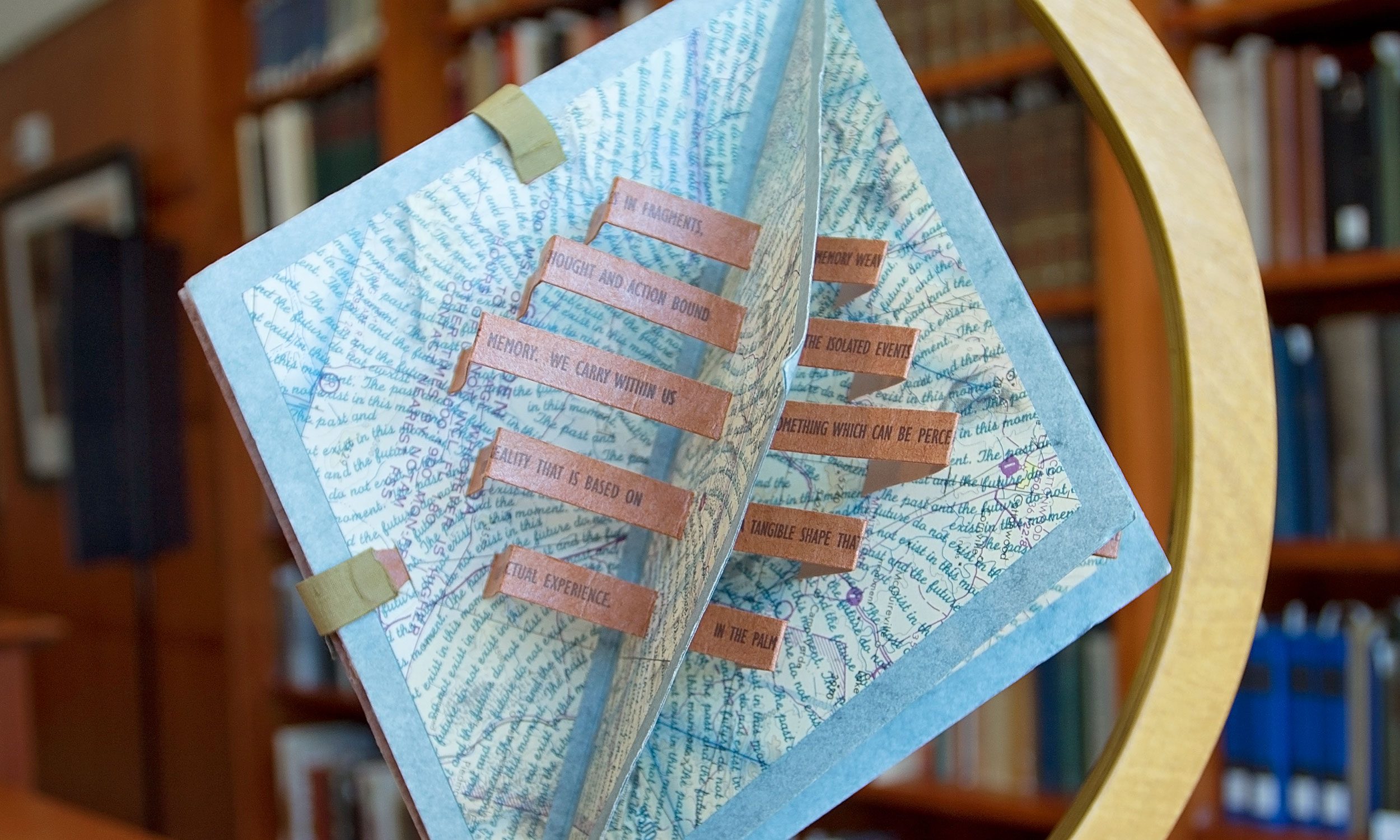 A book designed with an architectural, origami look that fits into a globe stand.