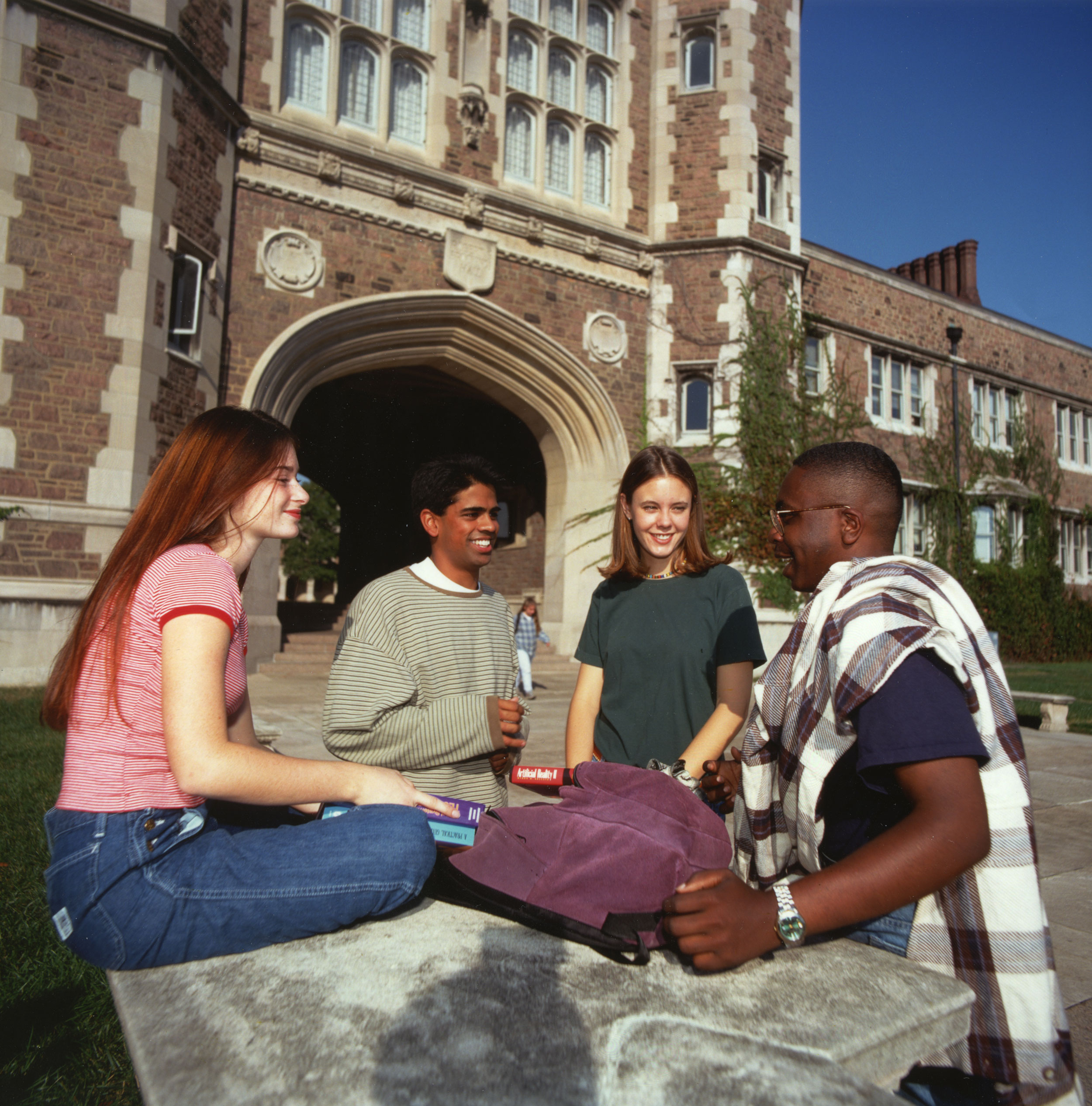 A group of four students gathered on the quad.