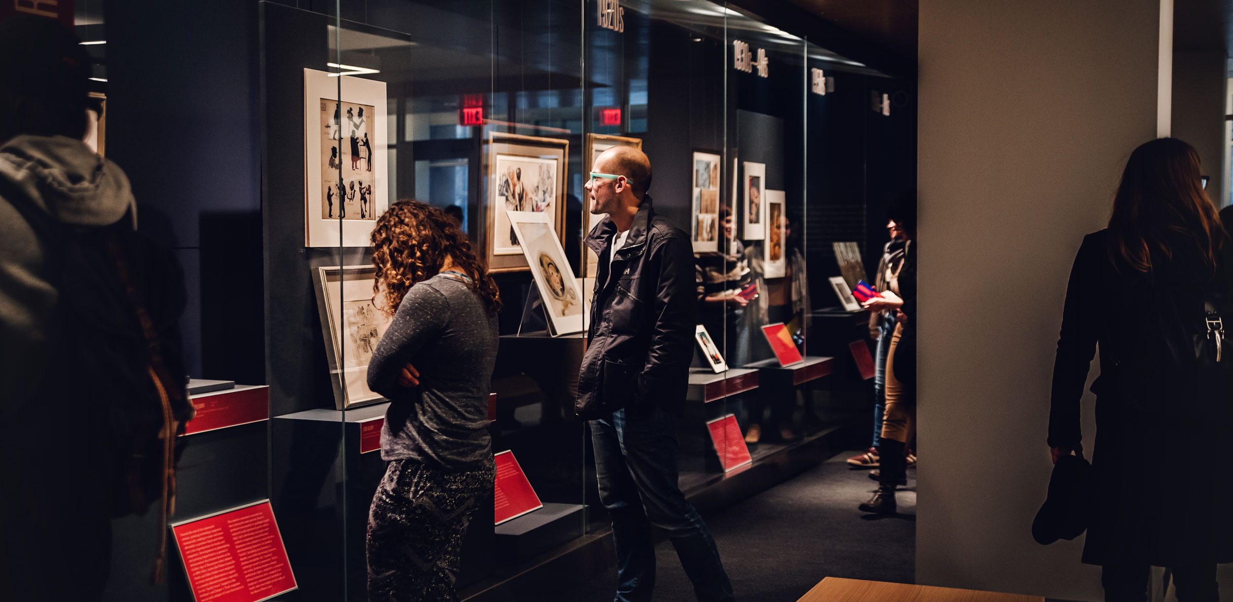 Students examining an exhibition on display in the Thomas Gallery on Level 1 of Olin Library.