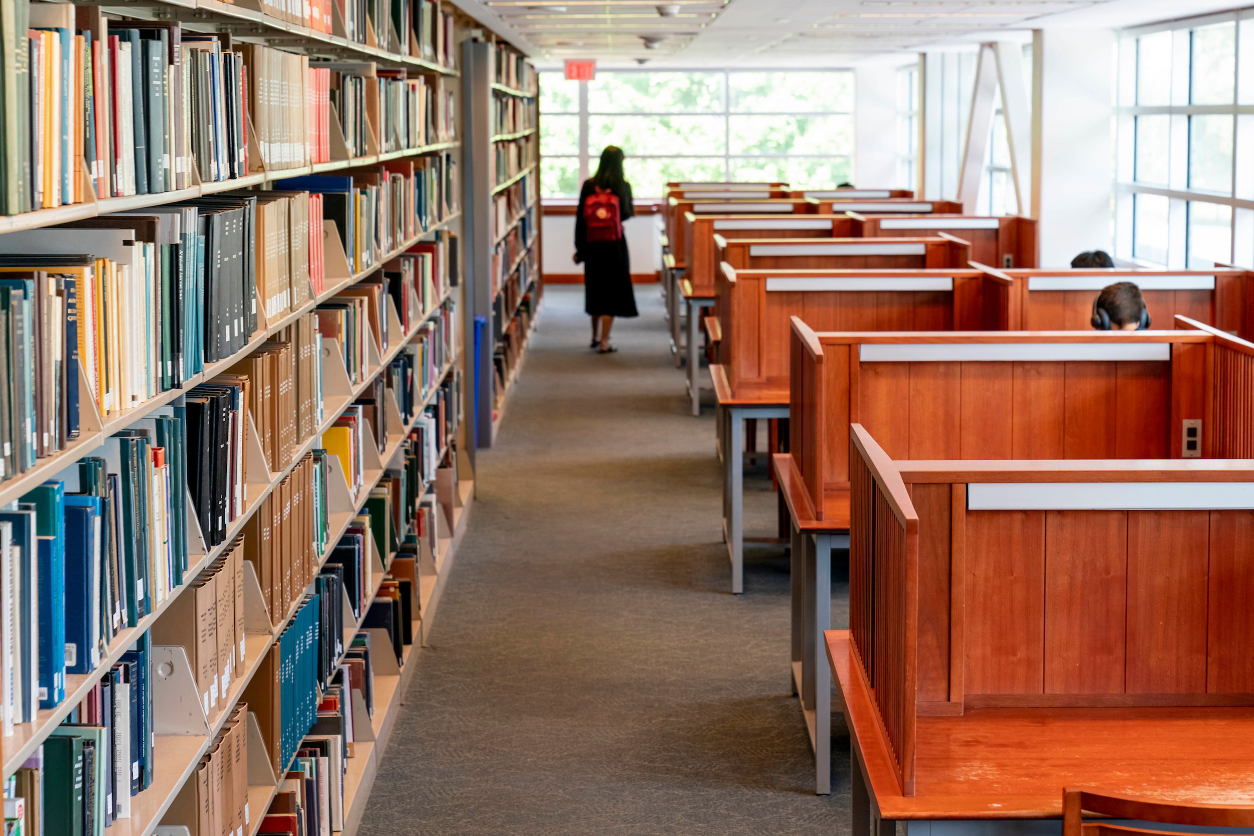 Student walking around the stacks on Level 2 of Olin Library.