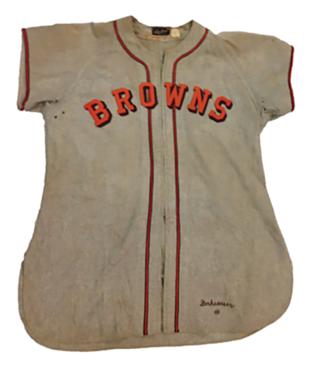 A Browns jersey. The jersey is short sleeved, white (though discolored with age) with red piping, and has the team name across the front.