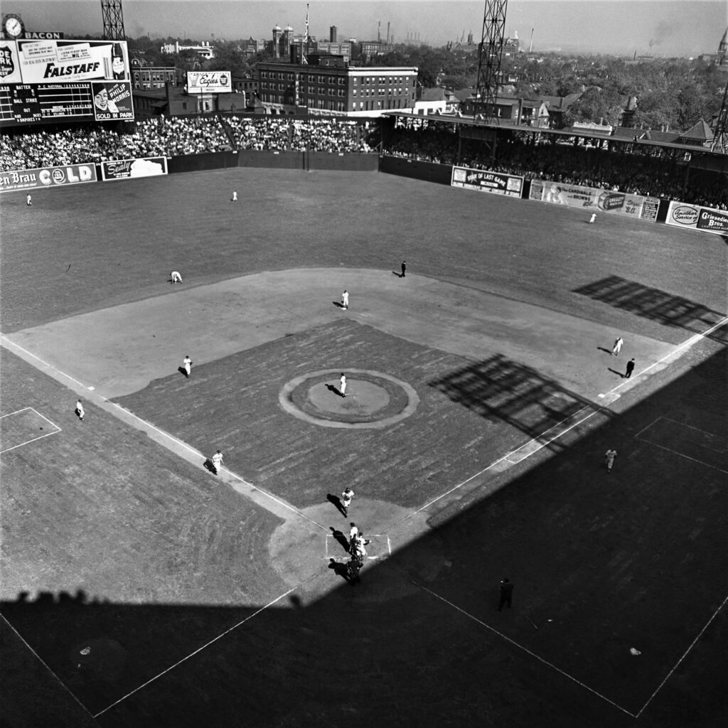 Sportsman Park as viewed from above; the baseball diamond and outfield can be seen in the shot, along with players on the field and a packed stadium of onlookers.