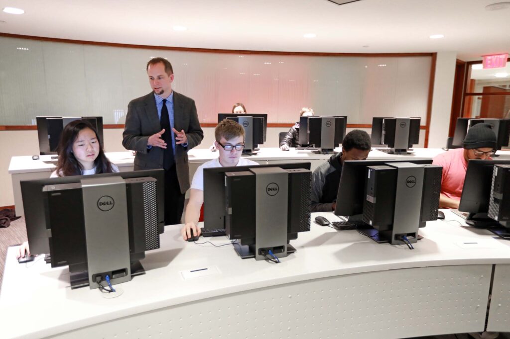 Students using the Instruction Room, a space with ten computer terminals on desks set in an auditorium style.