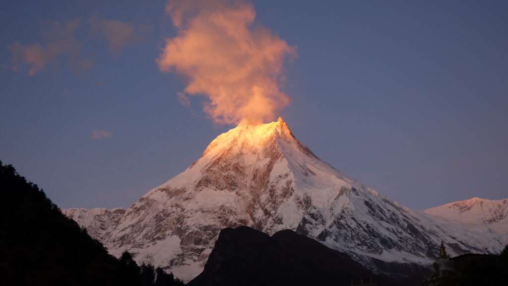 A snow capped mountain at dawn.