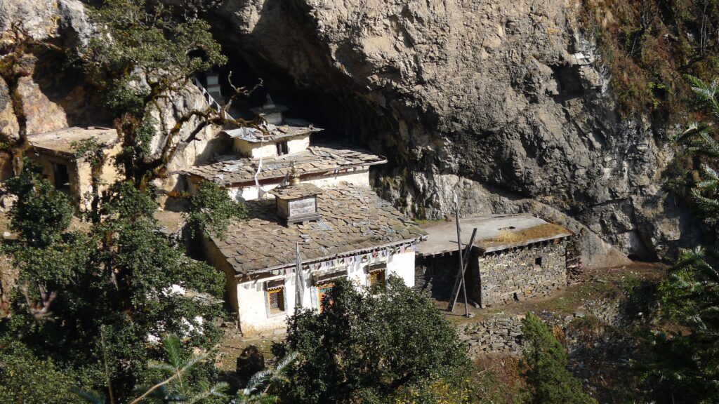 An old, dilapidated house built into the side of a mountain.