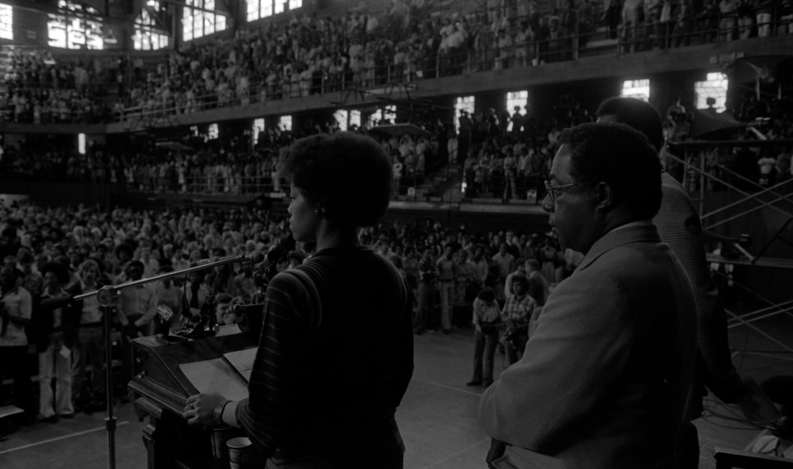 Jan Taylor is speaking at a podium to a large crowd gathered for Assembly Series speaker, Alex Haley.