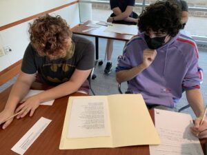 Students in the Special Collections classroom examine original drafts and typescripts of poems by May Swenson and James Merrill.