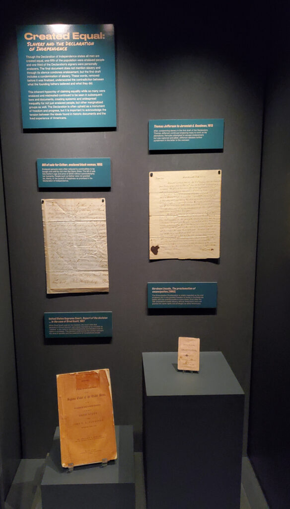 Four handwritten, original documents are on display.