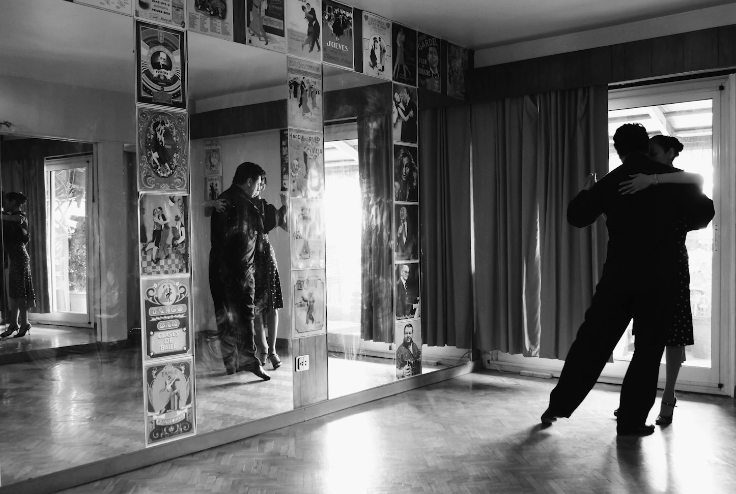 A couple dancing in a mirrored classroom.