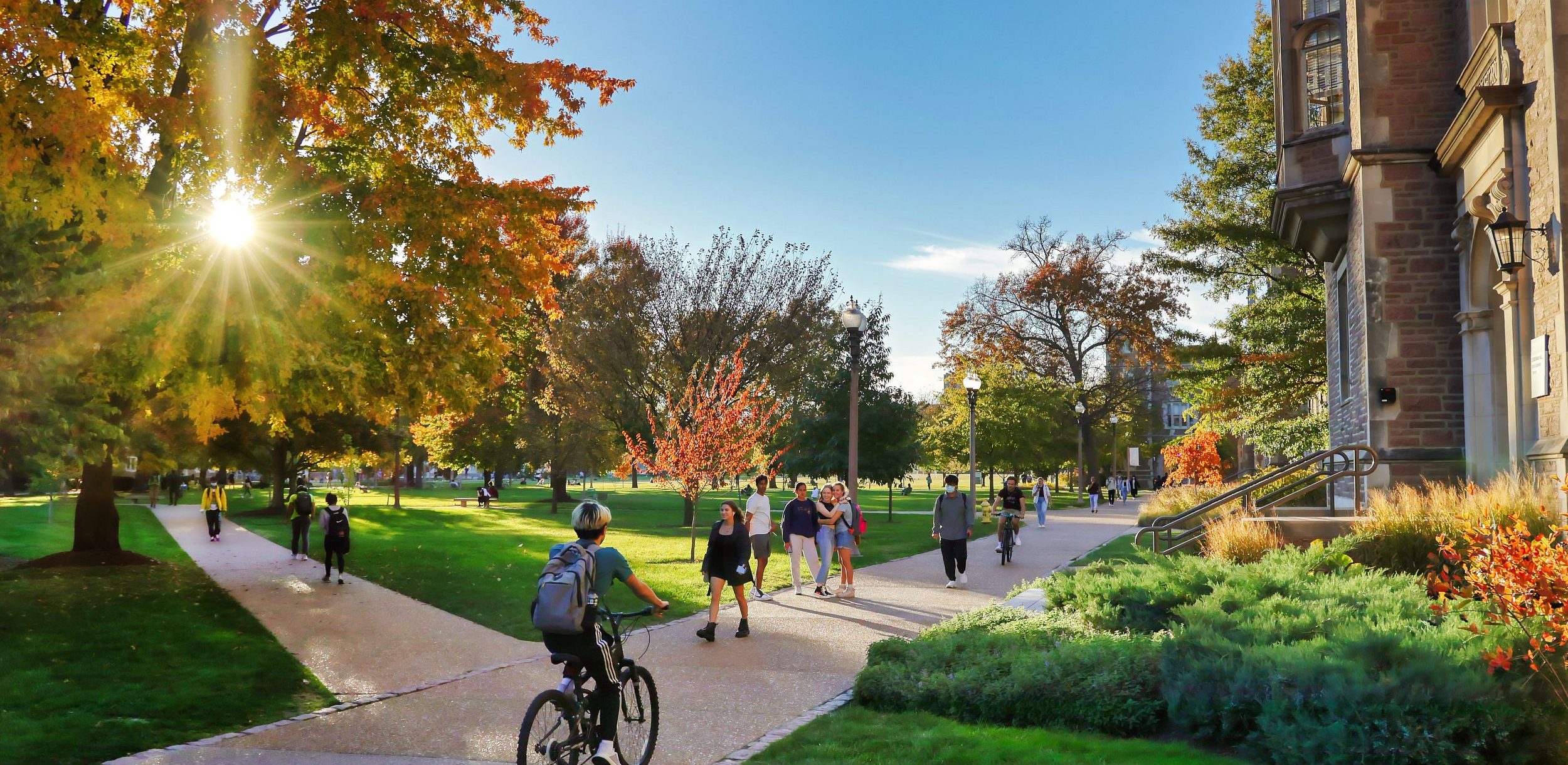 Students biking and walking across the Danforth Campus.