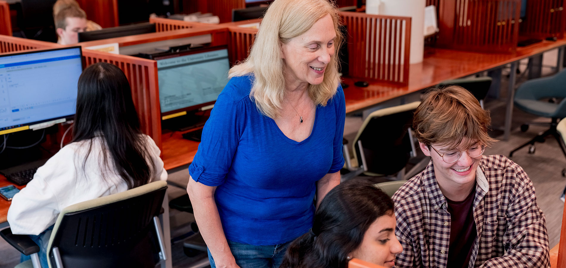 Librarian assisting two students