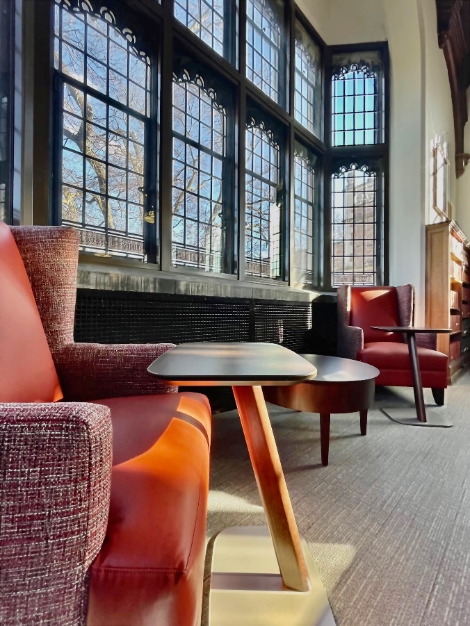 A line of tall windows overlooking an alcove with two sofa chairs.