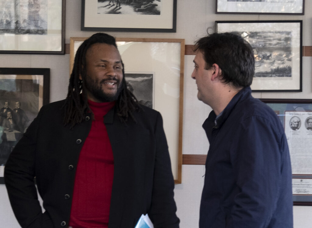 Poet Aaron Coleman speaking with faculty member Ignacio Infante.