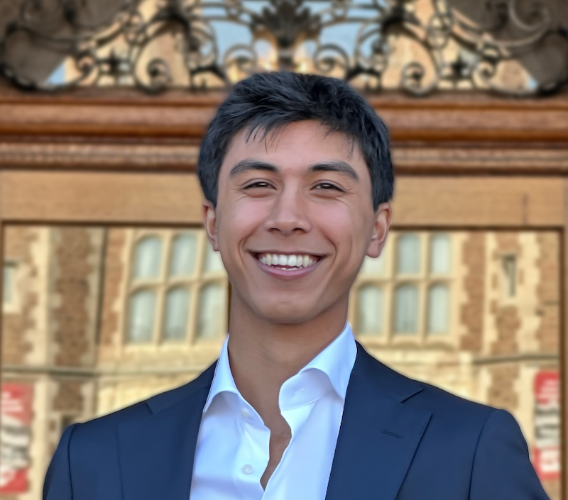 Portrait shot of a man smiling in front of a large door.