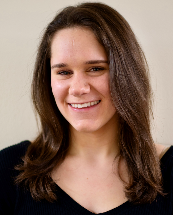 Headshot of a smiling, dark-haired woman.