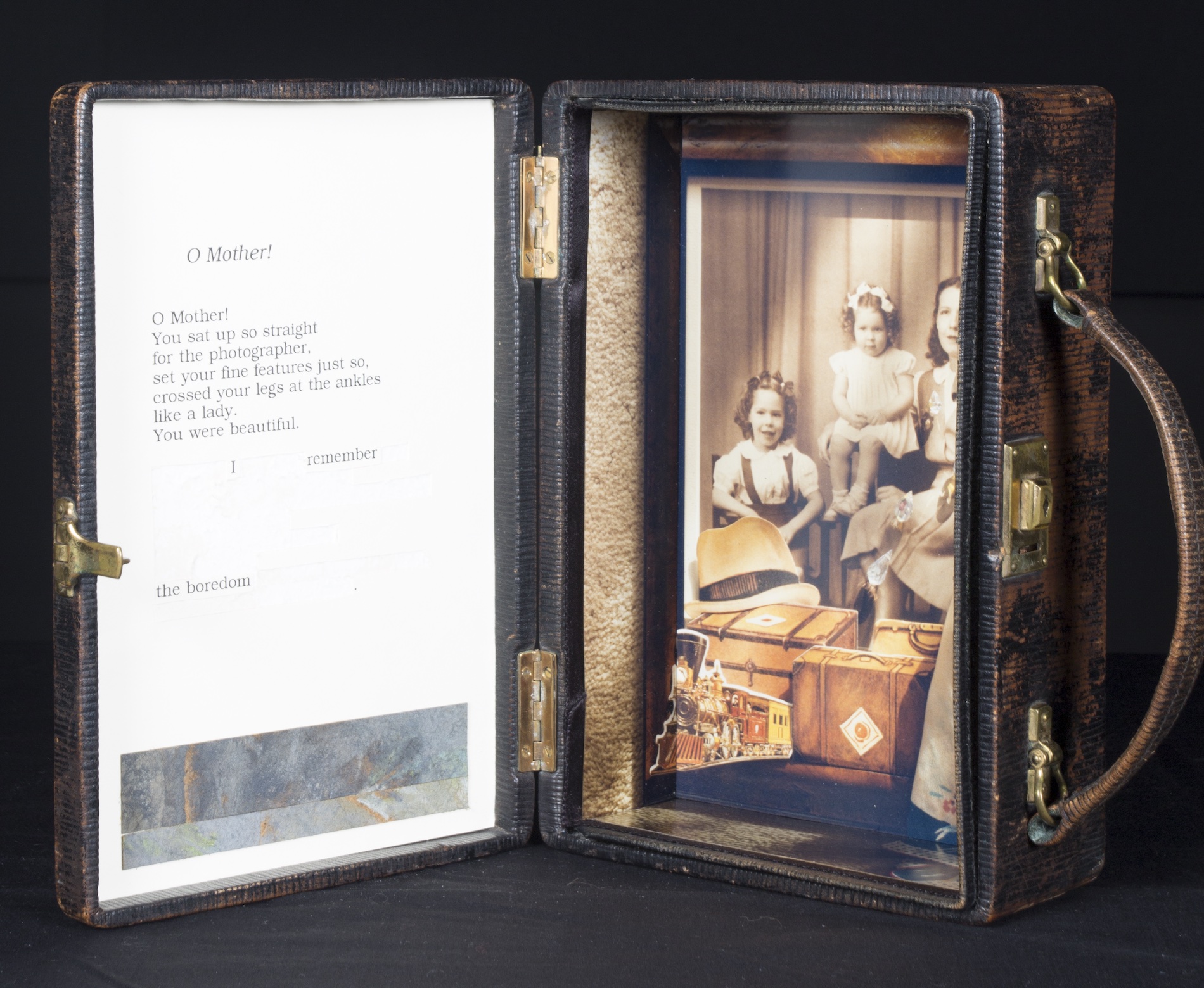 A poem and a framed photo on either sides of a small suitcase.