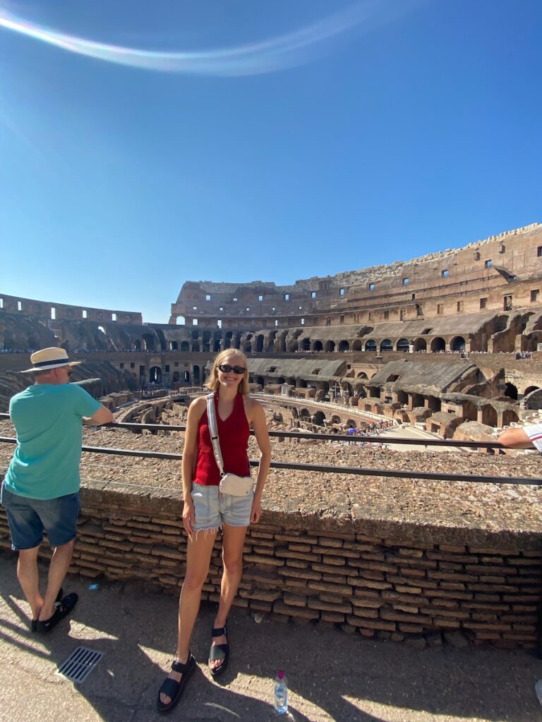 Woman standing in front of collossal ruins.