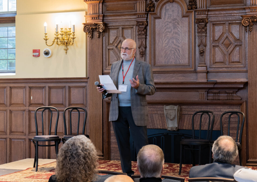 A man speaking on stage and people seated in front of him.