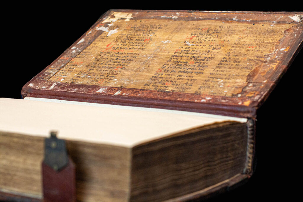 Old, hardbound book with a copper clasp open to the last page