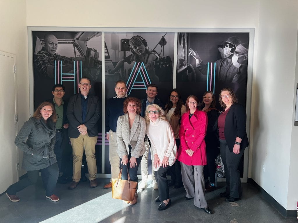 A group of people standing in front of glass doors.