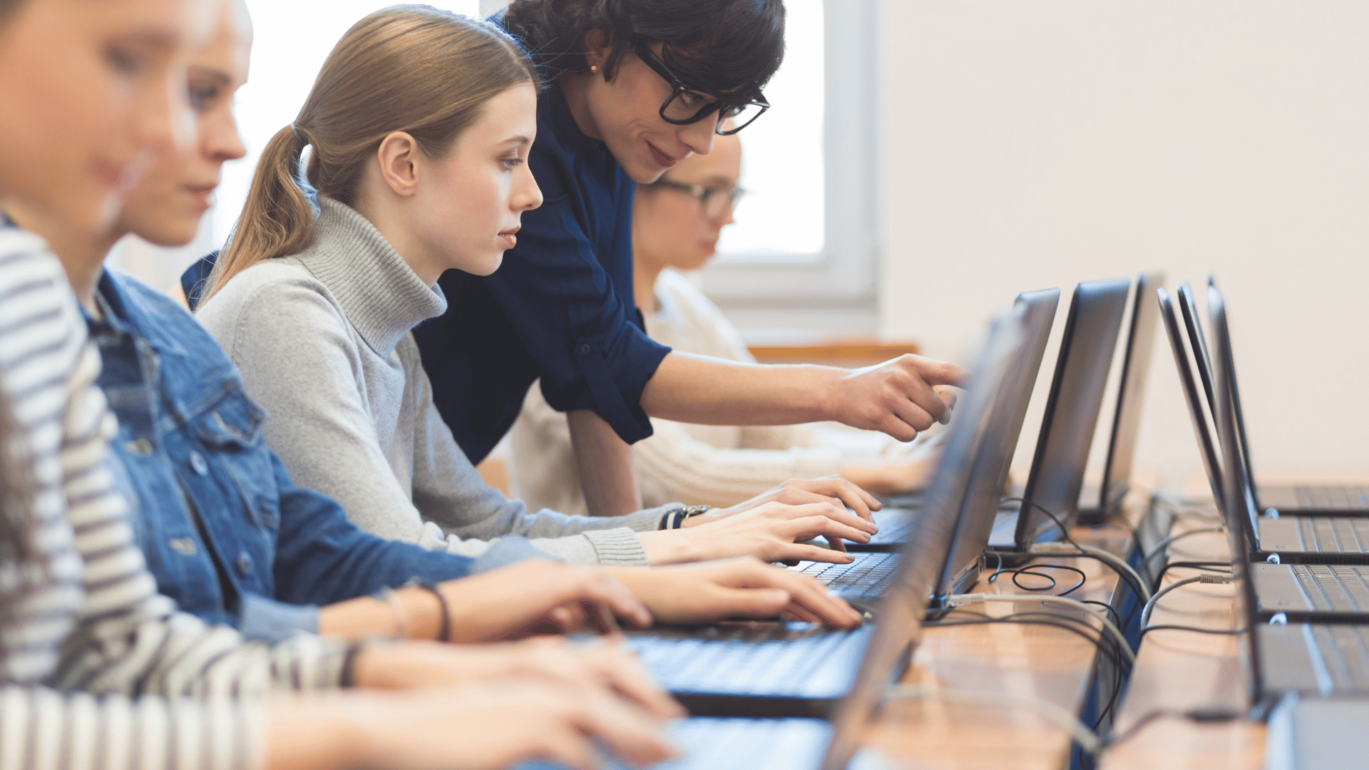 Students on computers with instructor assisting