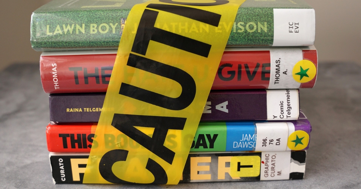 Stack of books with caution tape wrapped around them