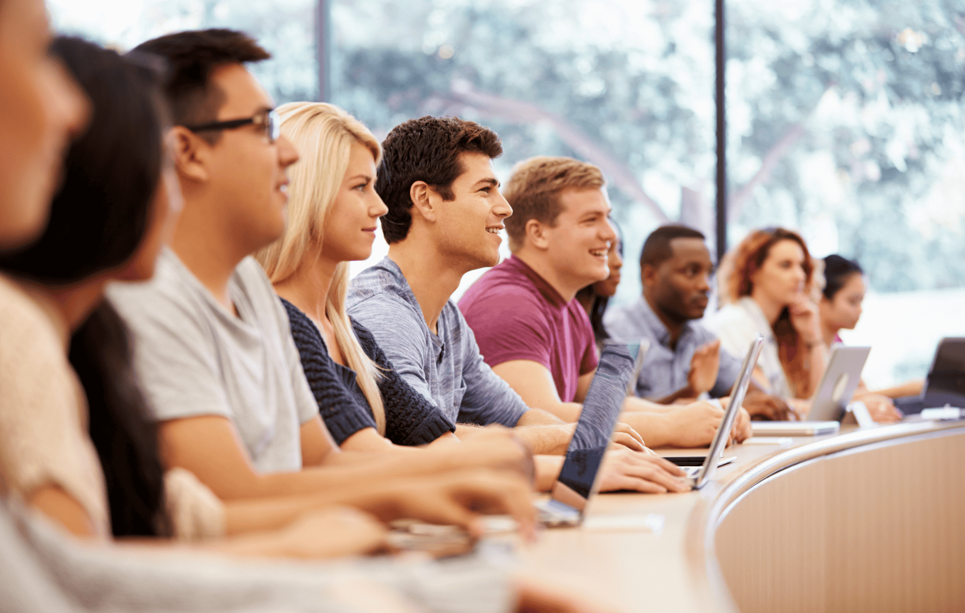 Group of college students using laptops in lecture