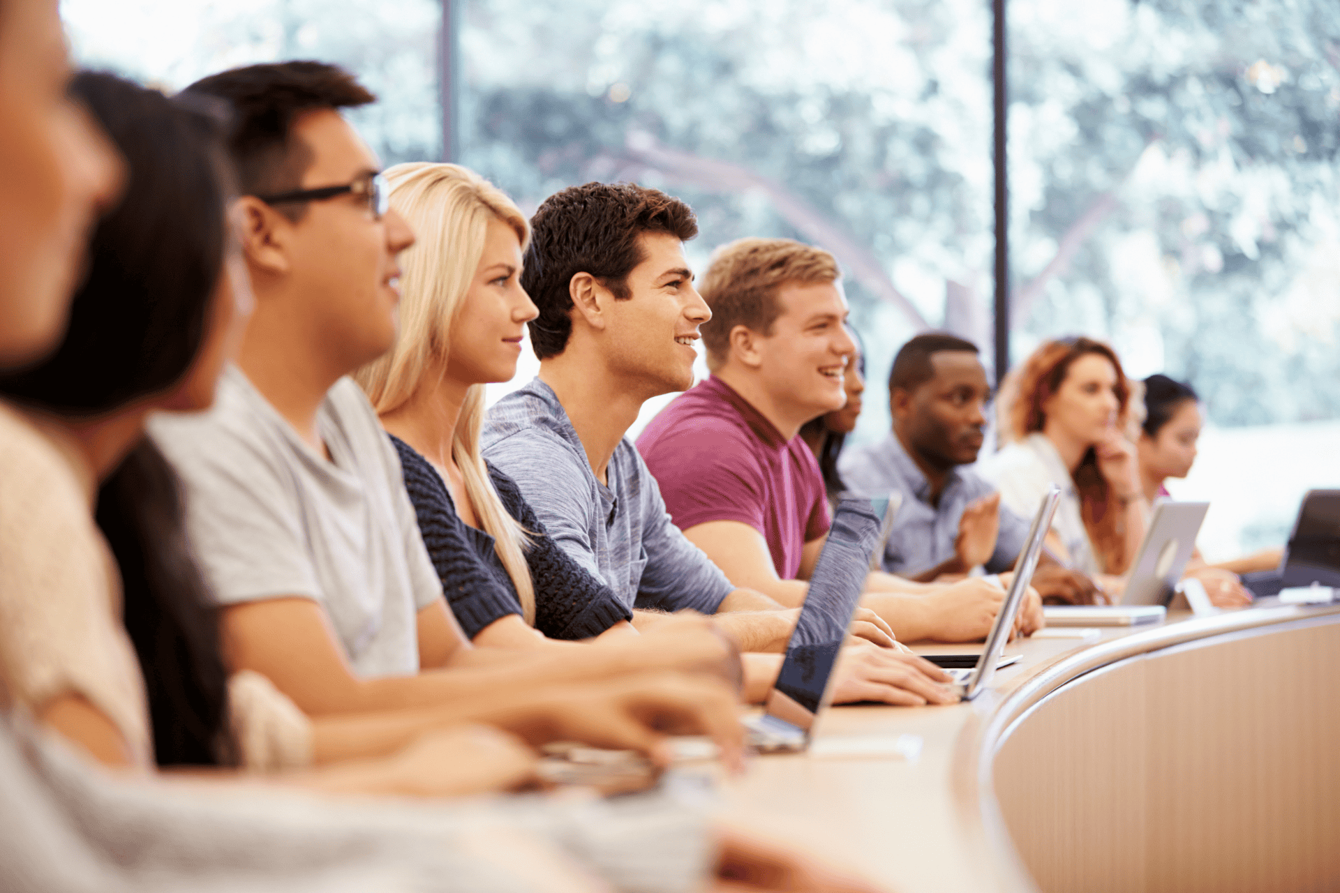 Group of college students using laptops in lecture