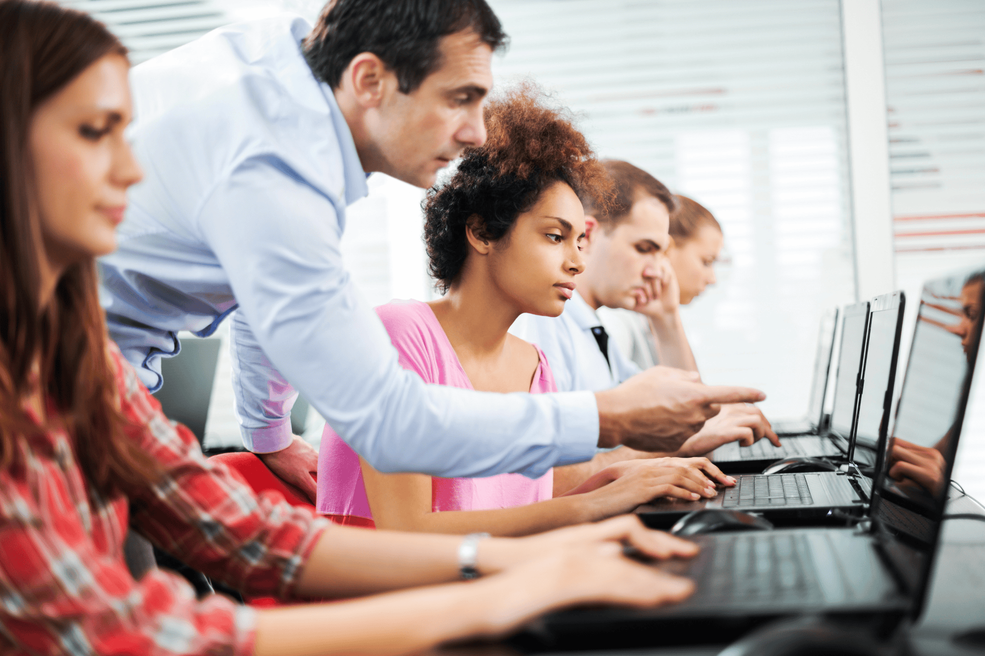 Stock photo of professor assisting a student on a laptop