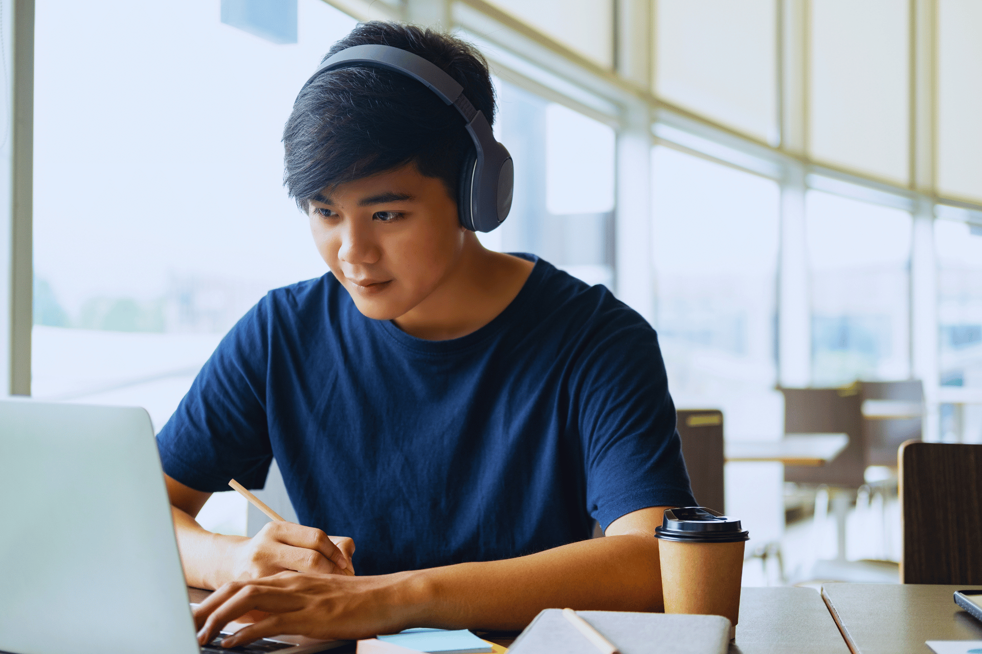 Student looking at laptop with headphones on