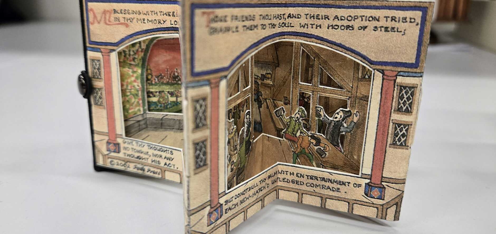 A miniature book with parts that mimic the movement of actors in a stage play.