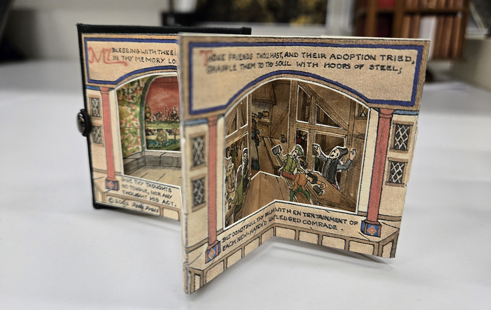 A miniature book with parts that mimic the movement of actors in a stage play.