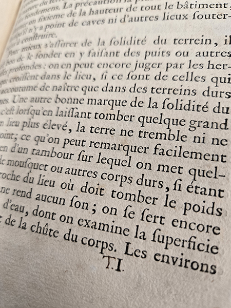 A page of a book written in French with an example of Thomas Jefferson's written initials (TJ) written under the text.