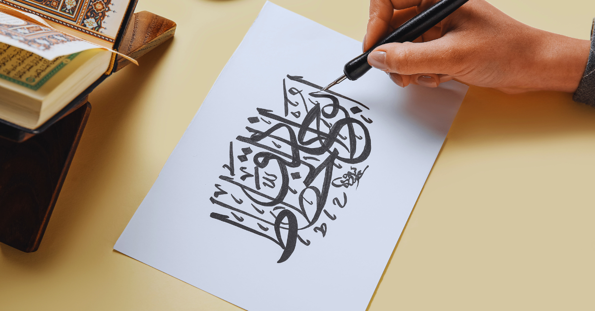 Stock photo of calligraphist writing Arabic on paper sheet against color background