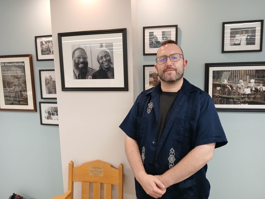 Man in front of a wall of portraits