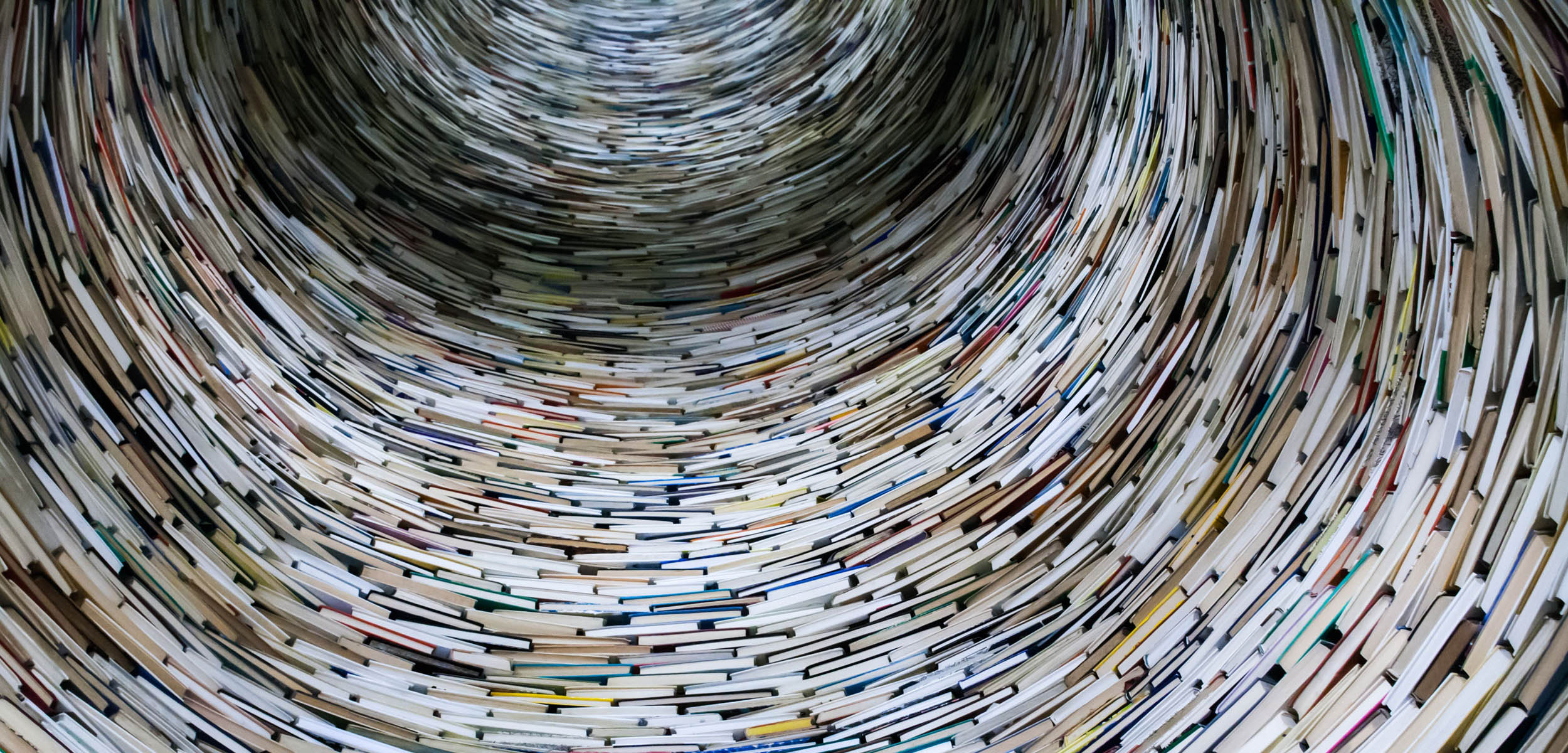 Books swirled spine-out in a column.
