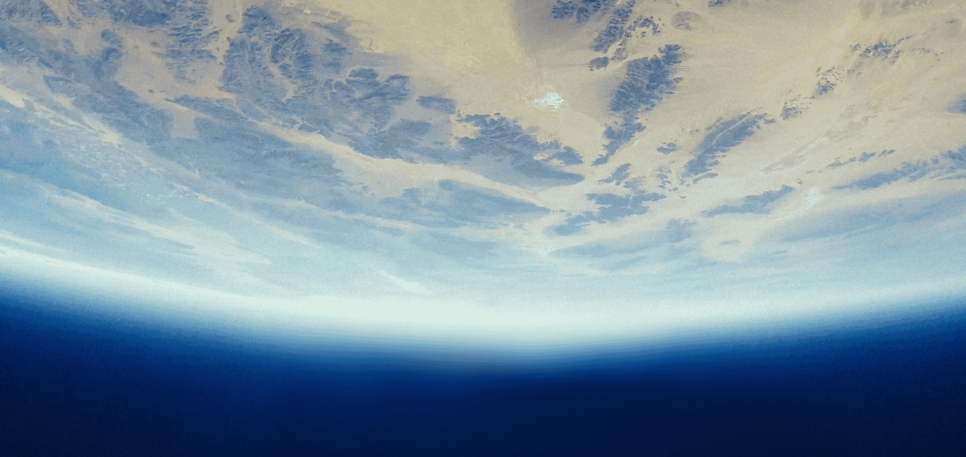 Abstract, satellite-style view of Earth showing pale tan landforms and textured terrain above a curved blue horizon that fades into deep ocean and atmosphere, evoking geospatial or global data visualization.
