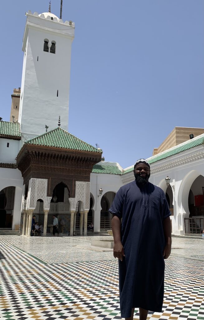 Man standing in front of a monument with a minaret