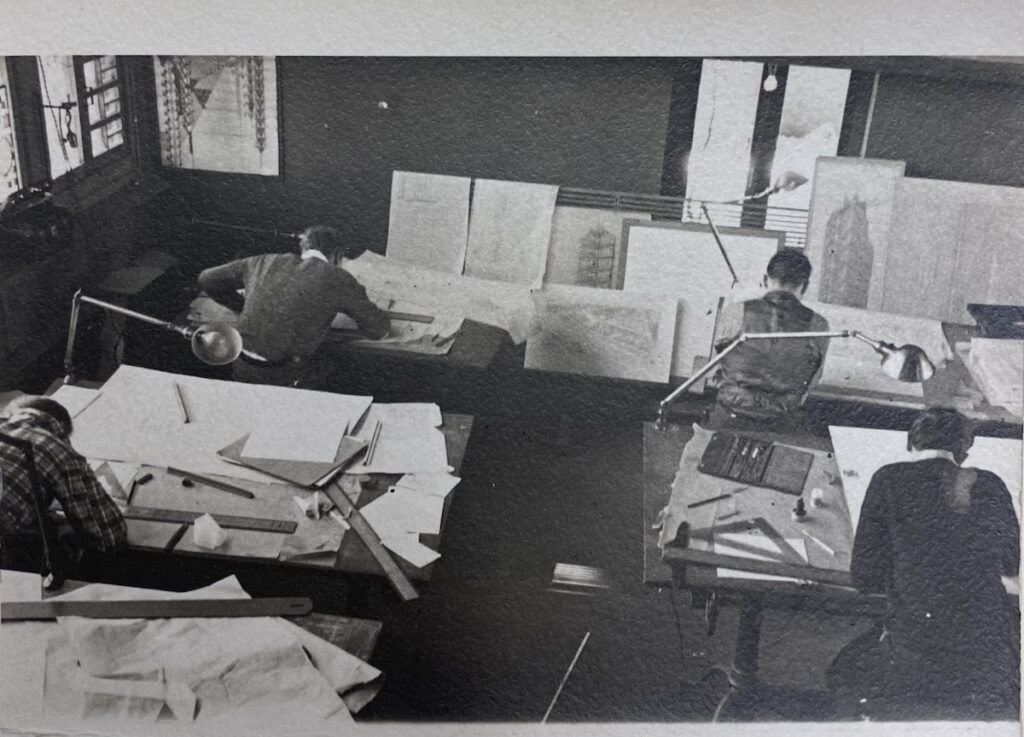 B&W photo of people seated at desks