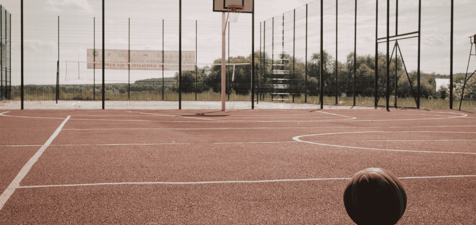 Outdoor basketball court with red surface and hoop