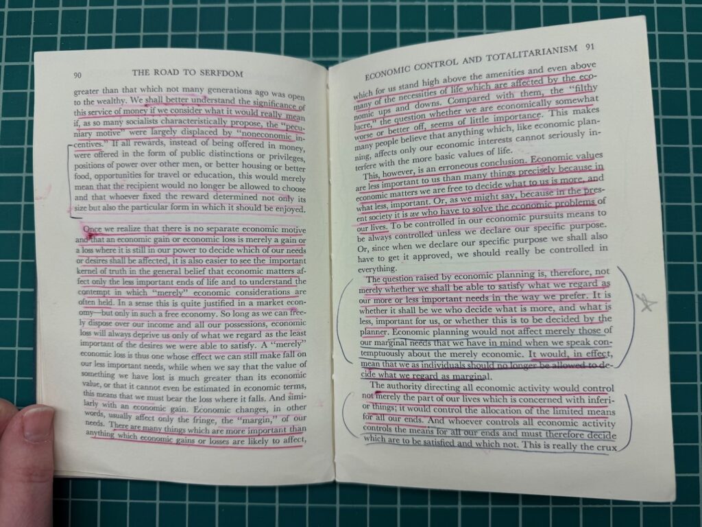 An open book with underlined sentences in pink ink