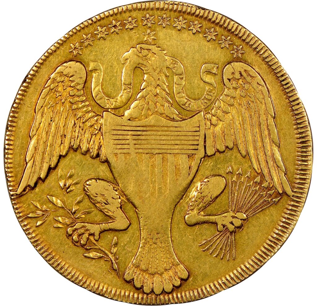 Reverse of Washington gold coin shows frontal Image of an eagle with wings outstretched, holding a twig of leaves and a bunch of arrows in left and right legs respectively, with a banner behind its head,