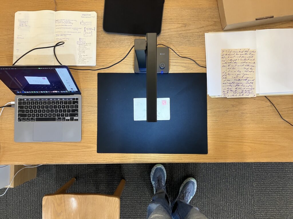 A desk with a laptop, scanner and documents