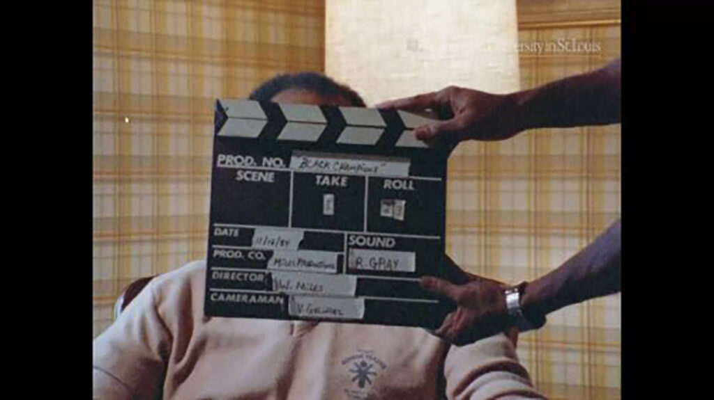William Miles Black Champions film marker clapper in front of an interview subject.
